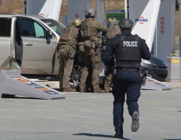 Royal Canadian Mounted Police officers prepare to take a suspect into custody at a gas station in Enfield, Nova Scotia, on April 19, 2020. (Tim Krochak/The Canadian Press via AP)