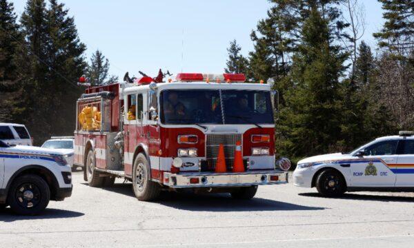 Royal Canadian Mounted Police (RCMP) monitor Portapique Beach Road, as a fire truck travels along it after searching for Gabriel Wortman, who the police describe as a shooter of multiple victims, in Portapique, Nova Scotia, Canada, on April 19, 2020. (John Morris/Reuters)