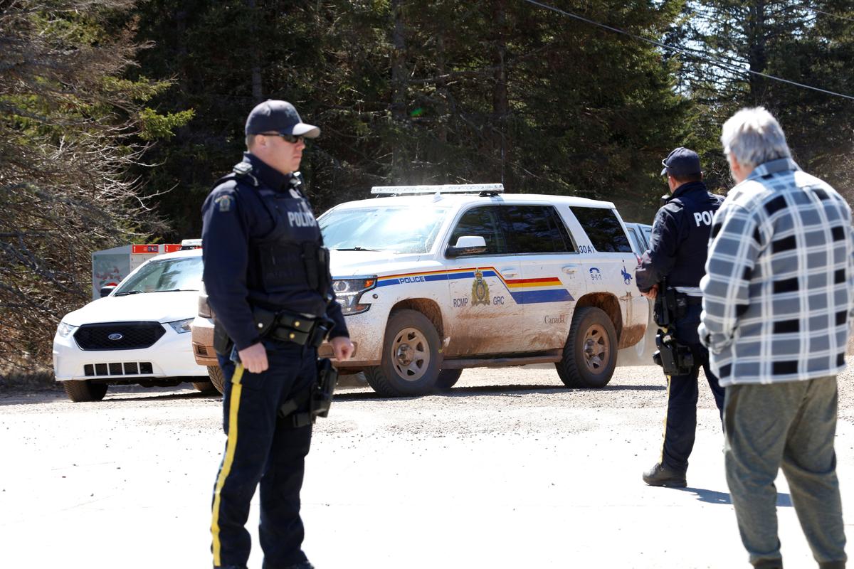 A Royal Canadian Mounted Police (RCMP) SUV pulls up to the end of Portapique Beach Road while an officer speaks with a man after the police finished their search for a shooter of multiple victims in Portapique, Nova Scotia, Canada, on April 19, 2020. (John Morris/Reuters)