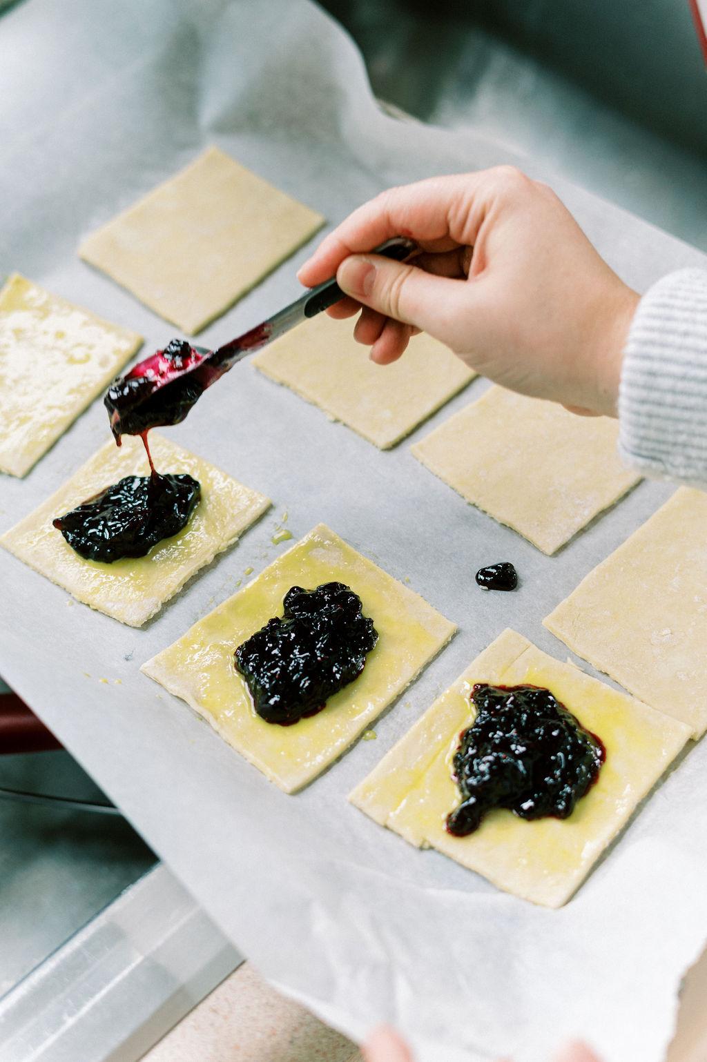 Dolloping jam filling onto the centers of the tarts. (Matt Genders Photography)