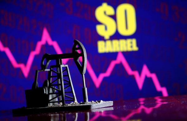 A 3D-printed oil pump jack is seen in front of a displayed stock graph with "$0 Barrel" written on it, on April 20, 2020. (Dado Ruvic/Reuters)