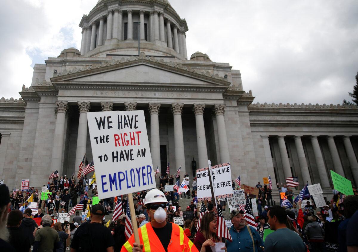 A man wears a mask and construction gear during a protest against the state's extended stay-at-home order at the Capitol building in Olympia, Washington, on April 19, 2020. (Lindsey Wasson/Reuters)
