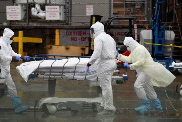Medical personnel move a deceased patient to a refrigerated truck serving as a makeshift morgue at Brooklyn Hospital Center in New York City on April 9, 2020. (Angela Weiss/AFP via Getty Images)