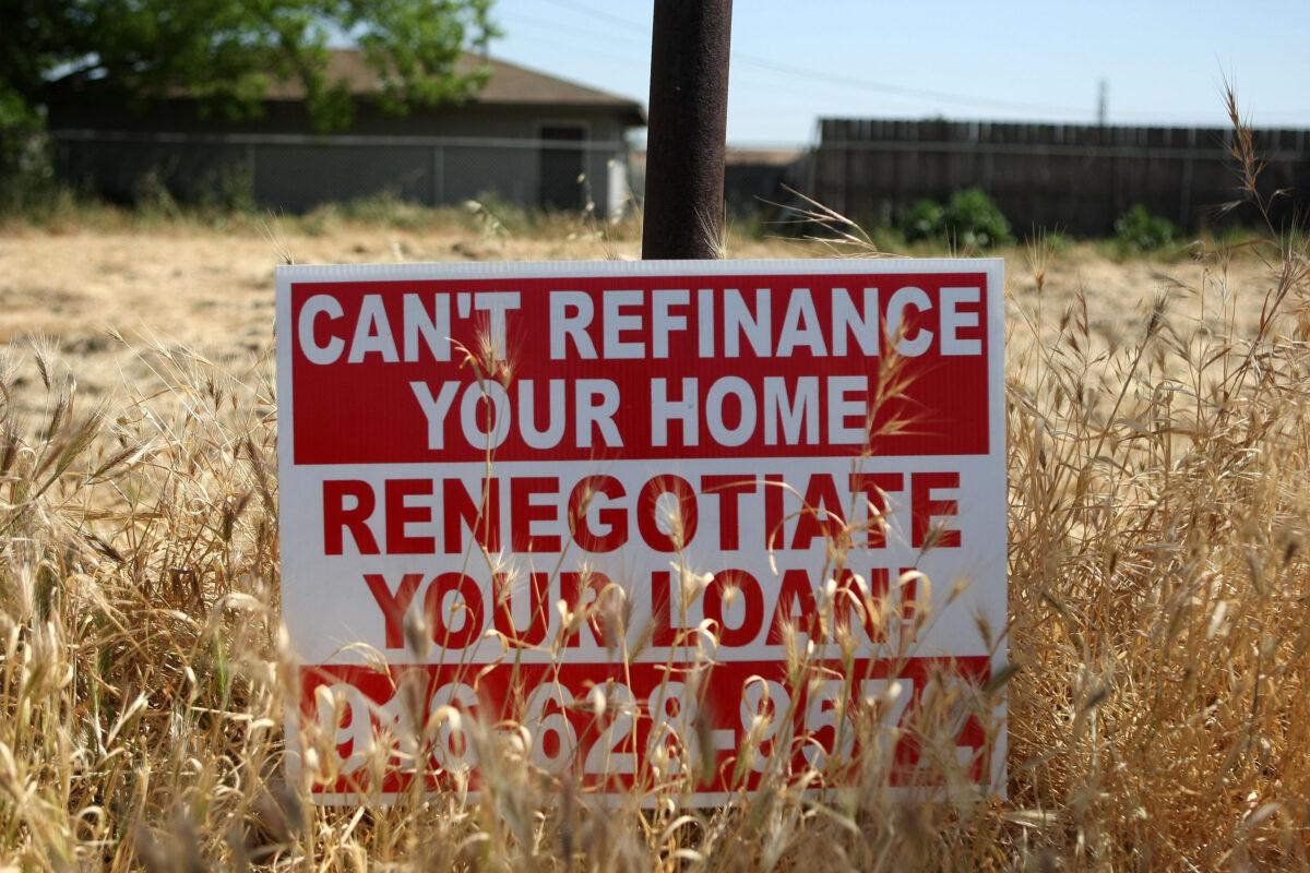 A sign advertising refinancing services is posted in a vacant lot in Stockton, California, on April 29, 2008. (Justin Sullivan/Getty Images)