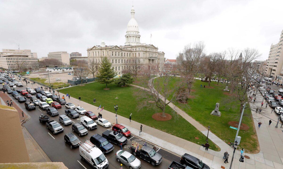 The Michigan State Capitol is seen in the background as people in vehicles protest lockdown orders, in Lansing, Mich., on April 15, 2020. (Jeff Kowalsky/AFP via Getty Images)