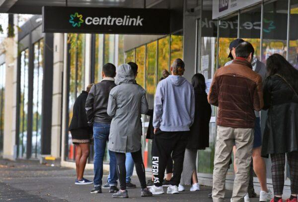 People queue up outside a Centrelink office for government payments in Melbourne on April 20, 2020. ( William WEST / AFP via Getty Images )