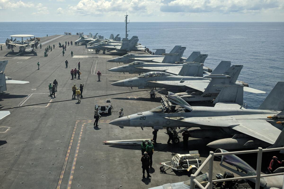 U.S. Navy F/A-18 Super Hornets multirole fighters and an EA-18G Growler electronic warfare aircraft (2nd R) on board USS Ronald Reagan (CVN-76) aircraft carrier as it sails in the South China Sea on its way to Singapore on Oct. 16, 2019. (Catherine Lai/AFP via Getty Images)