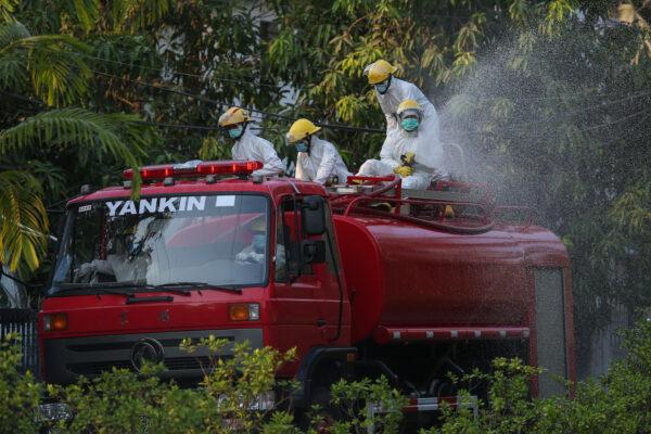 Firefighters spray disinfectant as a preventive measure against the spread of the COVID-19 novel CCP virus in Yangon, Burma, on April 20, 2020. (Sai Aung Main/AFP via Getty Images)