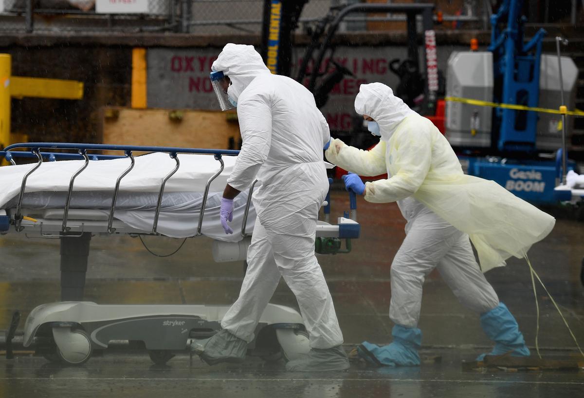 Medical personnel move a deceased patient to a refrigerated truck serving as a make-shift morgue at Brooklyn Hospital Center in New York City, on April 9, 2020. (Angela Weiss / AFP/Getty Images)