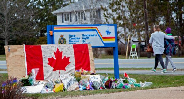 A woman comforts her daughter after they placed flowers at an impromptu memorial in front of the RCMP detachment in Enfield, Nova Scotia, on April 20, 2020. (Tim Krochak/Getty Images)