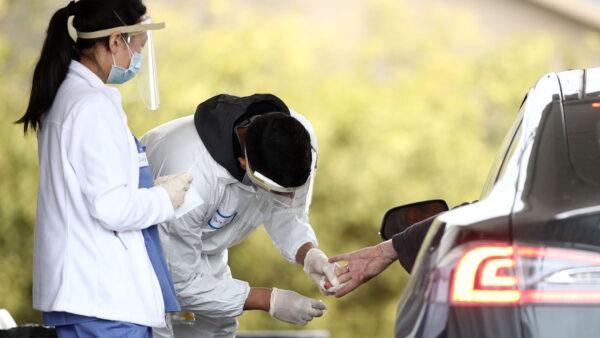 A medical professional administers a coronavirus (covid-19) test at a drive thru testing location conducted by staffers from the University of California, San Francisco Medical Center (UCSF) in the parking lot of the Bolinas Fire Department in Bolinas, Calif.,on April 20, 2020. (Ezra Shaw/Getty Images)