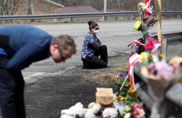 Mourners look at a makeshift memorial for the RCMP Constable Heidi Stevenson, who was killed during the April 18-19, 2020, killings in rural Nova Scotia, in Shubenacadie, near Enfield, Nova Scotia, on April 22, 2020. (Reuters/Tim Krochak)