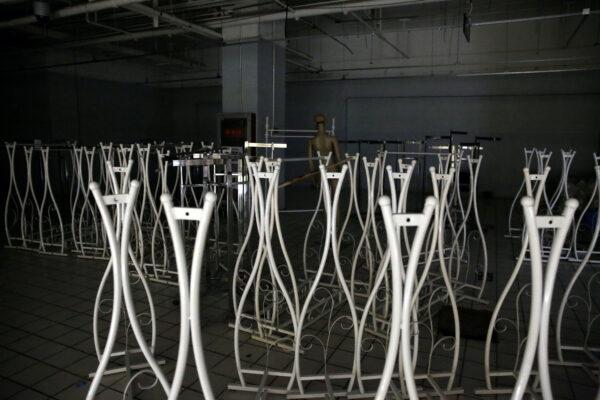 A mannequin and hangers are seen inside an empty clothing store after it went out of business following the COVID-19 outbreak, in Beijing, China, on April 17, 2020. (Tingshu Wang/Reuters)