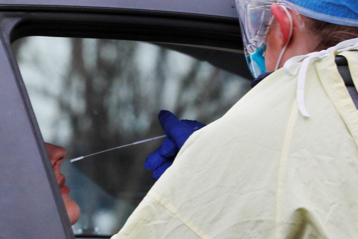 A medical technician takes a sample to test for COVID-19 at a drive-through testing site in Medford, Mass., on April 4, 2020. (Brian Snyder/Reuters)
