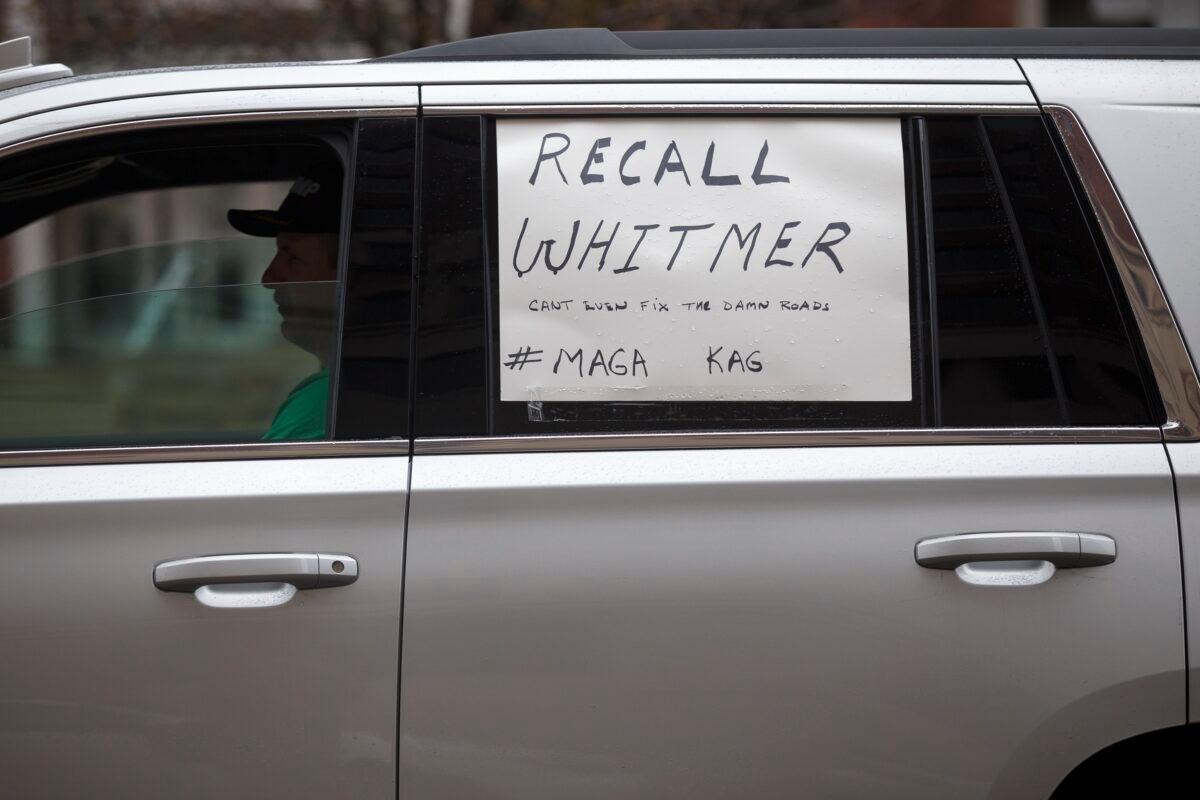 A man sits in his car while driving toward the Capitol along with many others to protest against Gov. Gretchen Whitmer's stay at home order, in Lansing, Michigan on April 15, 2020. (Elaine Cromie/Getty Images)