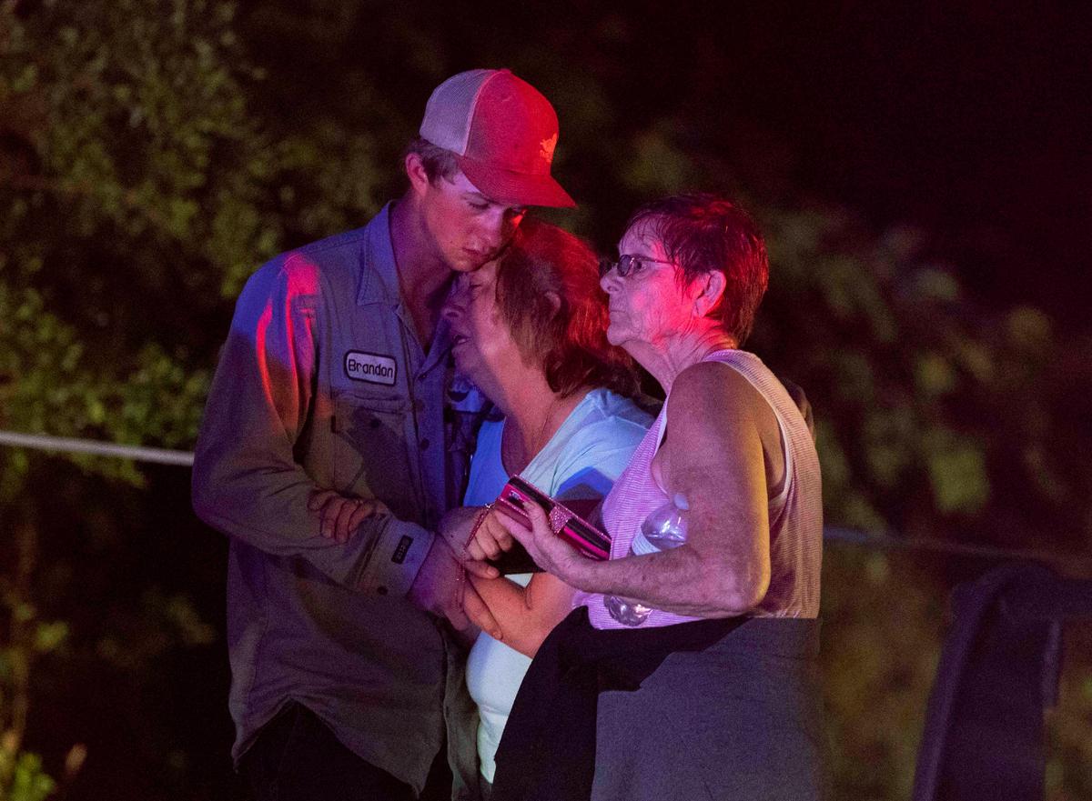 People embrace after an apparent tornado touched down in Onalaska, Texas on April 22, 2020. (Jason Fochtman/Houston Chronicle via AP)