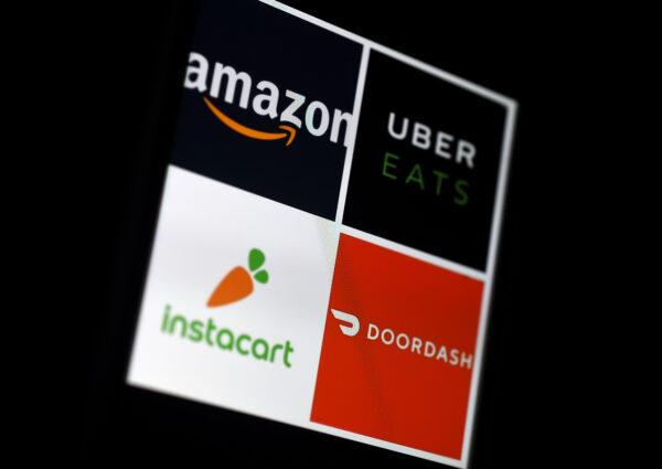 This illustration picture shows delivery applications logos from Amazon, Uber Eats, Instacart and Doordash displayed on a smartphone on April 10, 2020, in Arlington, Virginia. (Photo by Olivier Douliery/AFP/Getty Images)