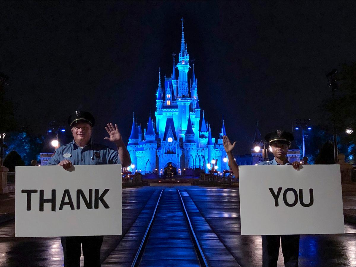 Until Disney theme parks are re-open, you can still experience some virtual fun through 360-degree videos filmed from a first-person view. Above, Walt Disney World Resort Security cast members Jack Cooper (L) and Branland Vaughn (R) hold “thank you” signs for medical workers while standing in front of Cinderella Castle at Magic Kingdom Park in Lake Buena Vista, Fla. (Disney)