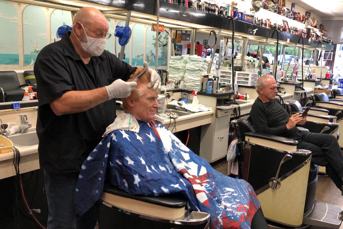 Barber Tommy Thomas, 69, gives his long-time customer Fred Bentley a haircut after the Georgia governor allowed a select number of businesses to open in Atlanta, Georgia on April 24, 2020. (Julio-Cesar Chavez/Reuters)