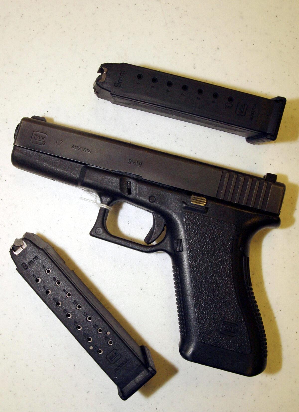 A Glock 9 mm pistol is displayed with two different capacity magazines, with the top clip holding 10 rounds and the bottom 18, at a shooting range in Bossier City, Louisiana, on Sept. 11, 2004. (Mario Villafuerte/Getty Images)