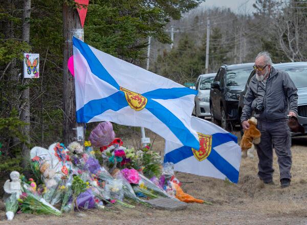 A man pays his respects at a roadside memorial in Portapique, Nova Scotia, Canada, on April 23, 2020. (Andrew Vaughan/The Canadian Press via AP)