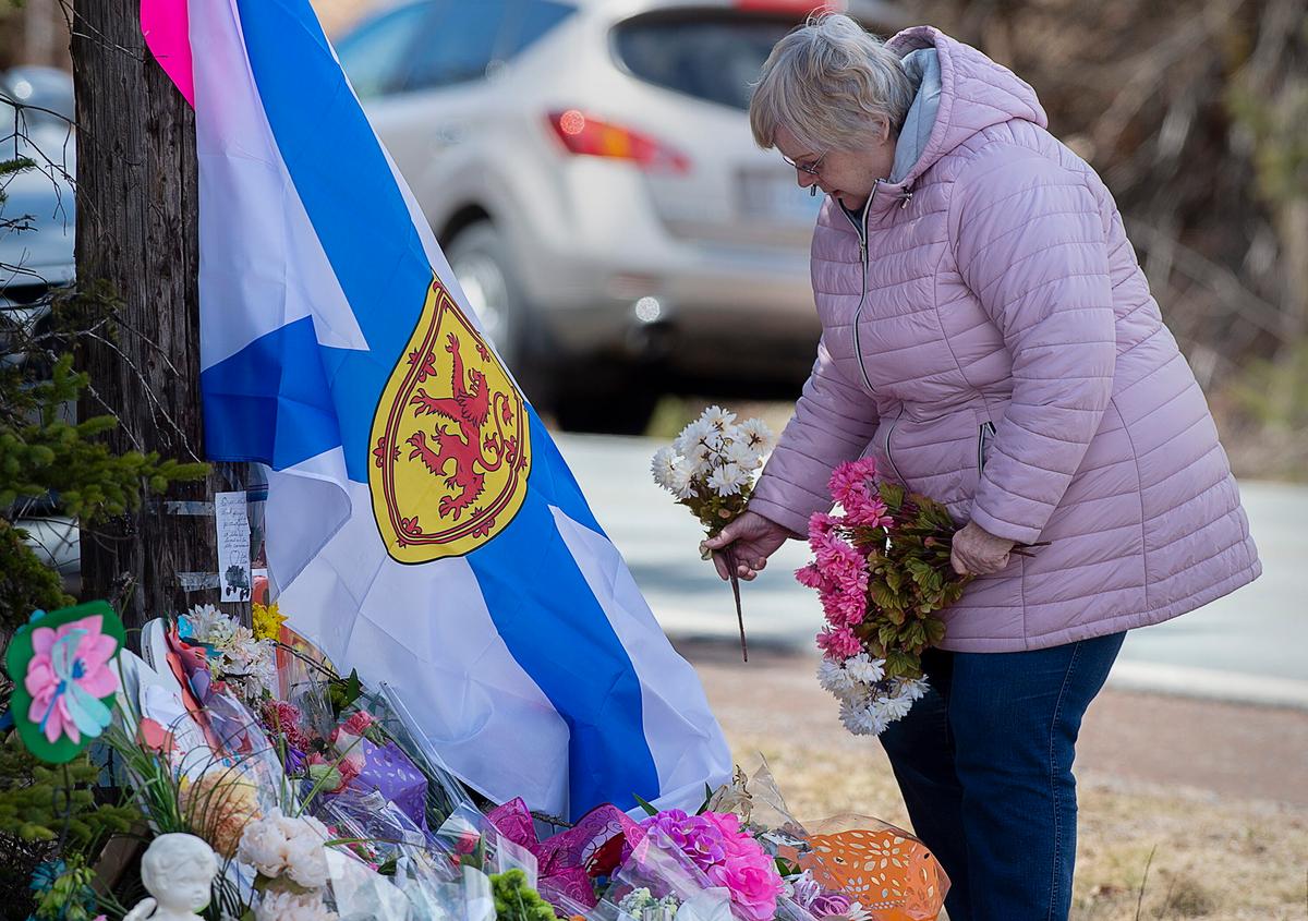 A woman pays her respects at a roadside memorial in Portapique, Nova Scotia, Canada, on April 23, 2020. (Andrew Vaughan/The Canadian Press via AP)