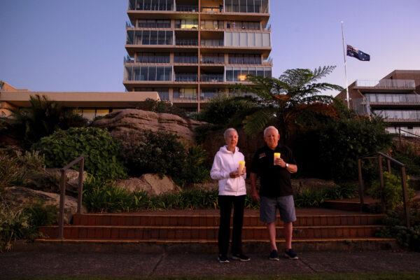 Ken and Jeanette Foster pay their respect outside their home in Fairlight, Australia, on April 25, 2020. (Cameron Spencer/Getty Images)