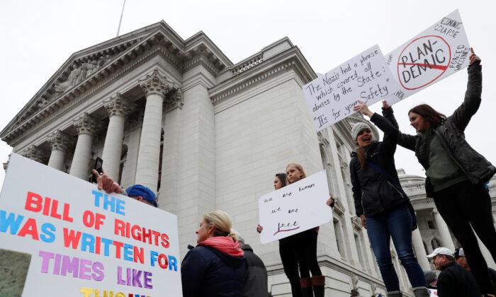 Demonstrators protest the extension of Wisconsin’s stay-at-home order outside the State Capitol building in Madison on April 24, 2020. (REUTERS/Shannon Stapleton)