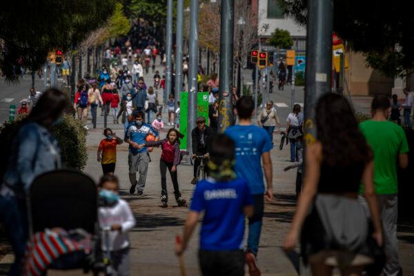 Families walk along a boulevard in Barcelona, Spain, on April 26, 2020 (Emilio Morenatti/ AP Photo)