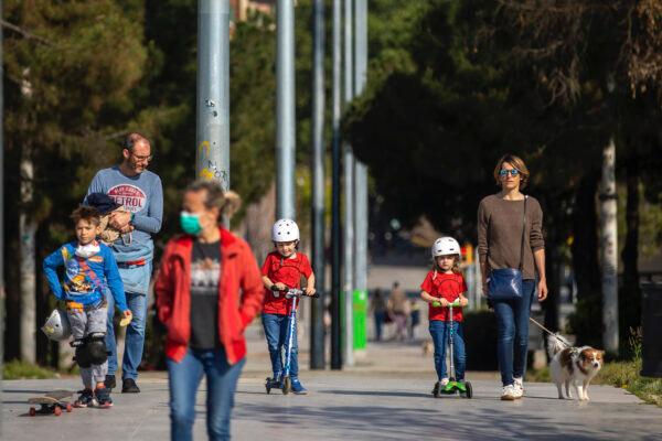 Families with their children walk along a boulevard in Barcelona, Spain, on April 26, 2020. (Emilio Morenatti/AP Photo)