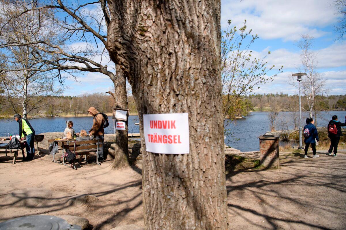 A sign on a tree reads “Avoid congestion” at the popular recreational area Hellasgarden in the outskirts of Stockholm, Sweden, on April 26, 2020, during the COVID-19 pandemic. (Henrik Montgomery/TT News Agency/AFP via Getty Images)