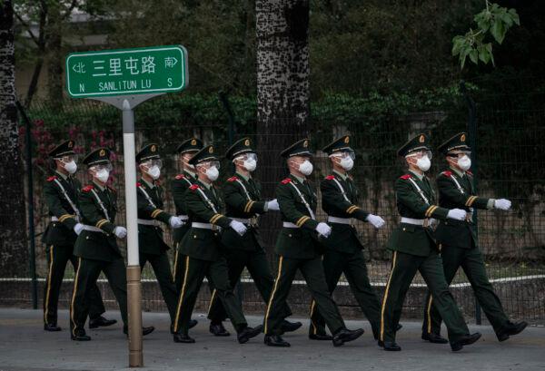 Chinese police wear protective masks as they march during a shift change in Beijing on April 14, 2020. (Kevin Frayer/Getty Images)