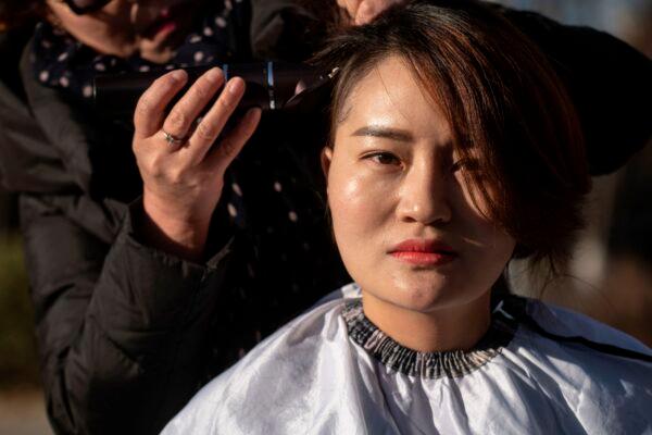 Li Wenzu has her head shaved to protest the detention of her husband and Chinese human rights lawyer Wang Quanzhang, detained during the 709 crackdown, in Beijing on Dec. 17, 2018. (Fred Dufour/AFP via Getty Images)