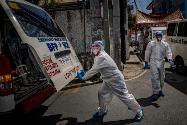 A medical personnel unloads patients to be tested for COVID-19 at a mass testing facility in San Juan, Metro Manila, Philippines, on April 24, 2020. (Ezra Acayan/Getty Images)