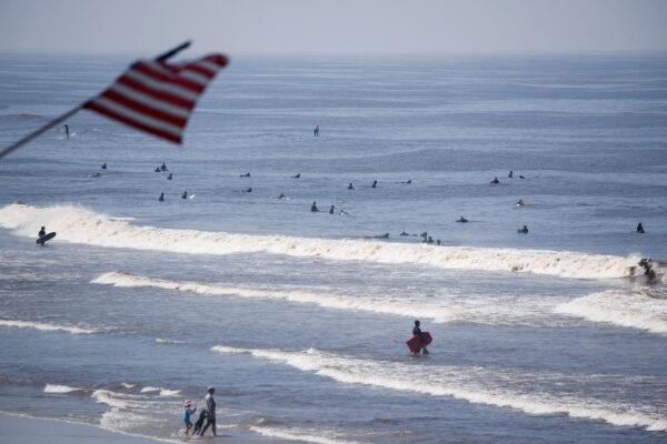 People return to the ocean after officials opened up a closed beach during the outbreak of the CCP virus (COVID-19) in Encinitas, Calif., on April 27, 2020. (Mike Blake/Reuters)