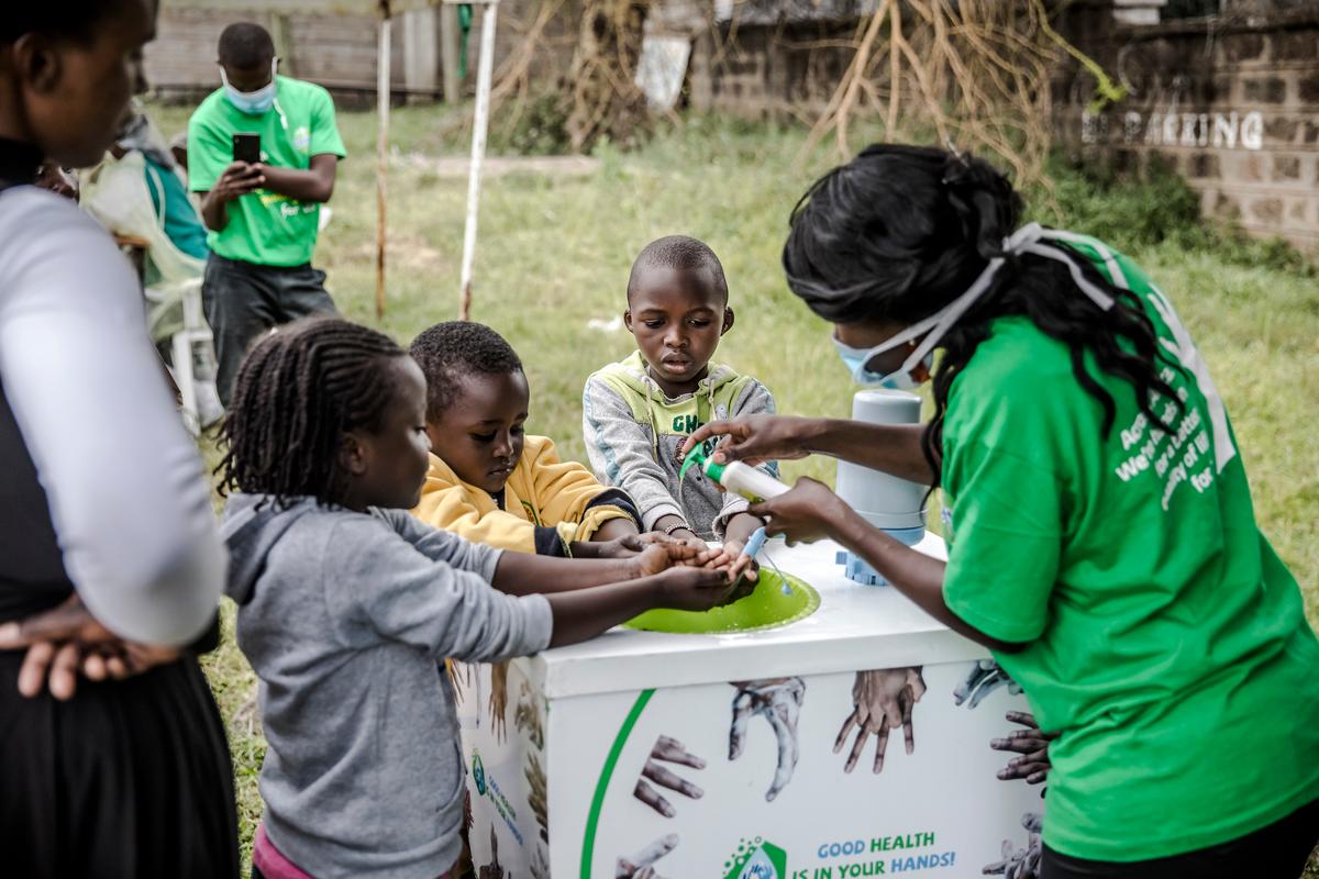 A worker instructs children on how to wash their hands at the entrance of the Mbagathi Hospital in Nairobi, Kenya, on March 18, 2020 (LUIS TATO/AFP via Getty Images)