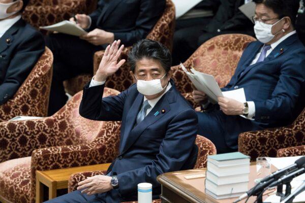 Japan's Prime Minister Shinzo Abe wearing a mask raises his hand to answer to a question during a budget committee meeting at the lower house of Parliament in Tokyo on April 28, 2020. (Tomohiro Ohsumi/Getty Images)