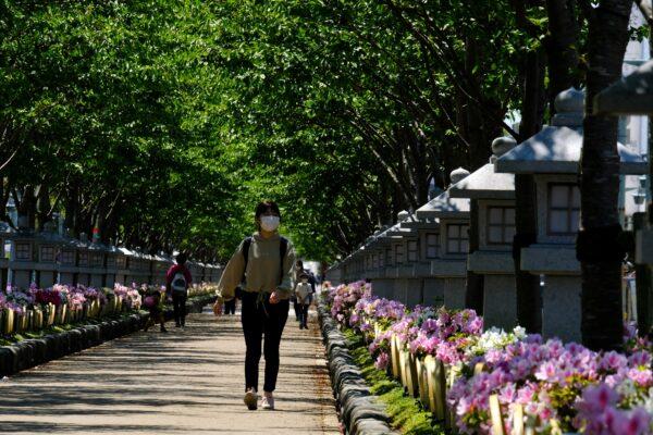 Amid concerns of the CCP virus, a woman walks along a path decorated with flowers leading to Tsuruoka Hachimangu, a symbolic shrine in Kamakura, Japan, on April 25, 2020. (Kazuhiro Nogi/AFP via Getty Images)