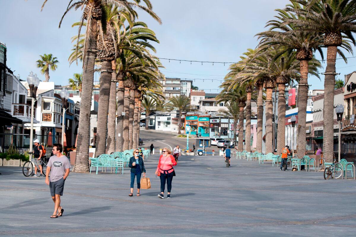 People walk around the entrance of the pier during CCP virus pandemic in Hermosa Beach, California, on April 28, 2020. (Valerie Macon/AFP via Getty Images)
