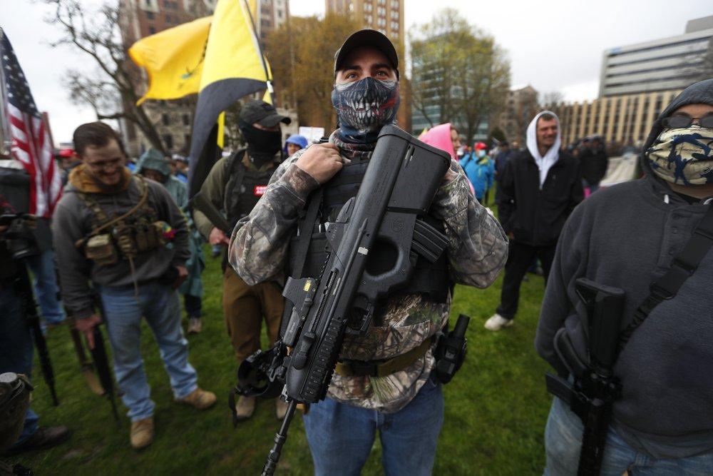 A protester carries his rifle at the State Capitol in Lansing, Mich., on April 30, 2020. (Paul Sancya/AP Photo)