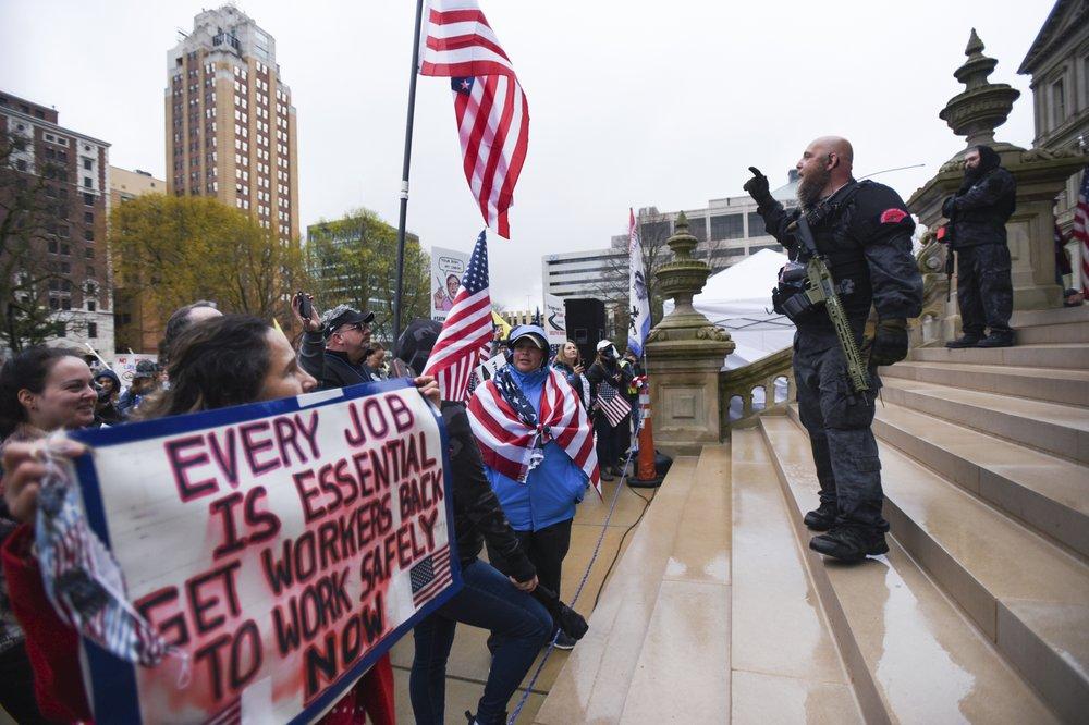 Members of the Michigan Liberty Militia, including Phil Robinson, right, join protesters at a rally at the state Capitol in Lansing, Mich., on April 30, 2020. (Matthew Dae Smith/Lansing State Journal via AP)