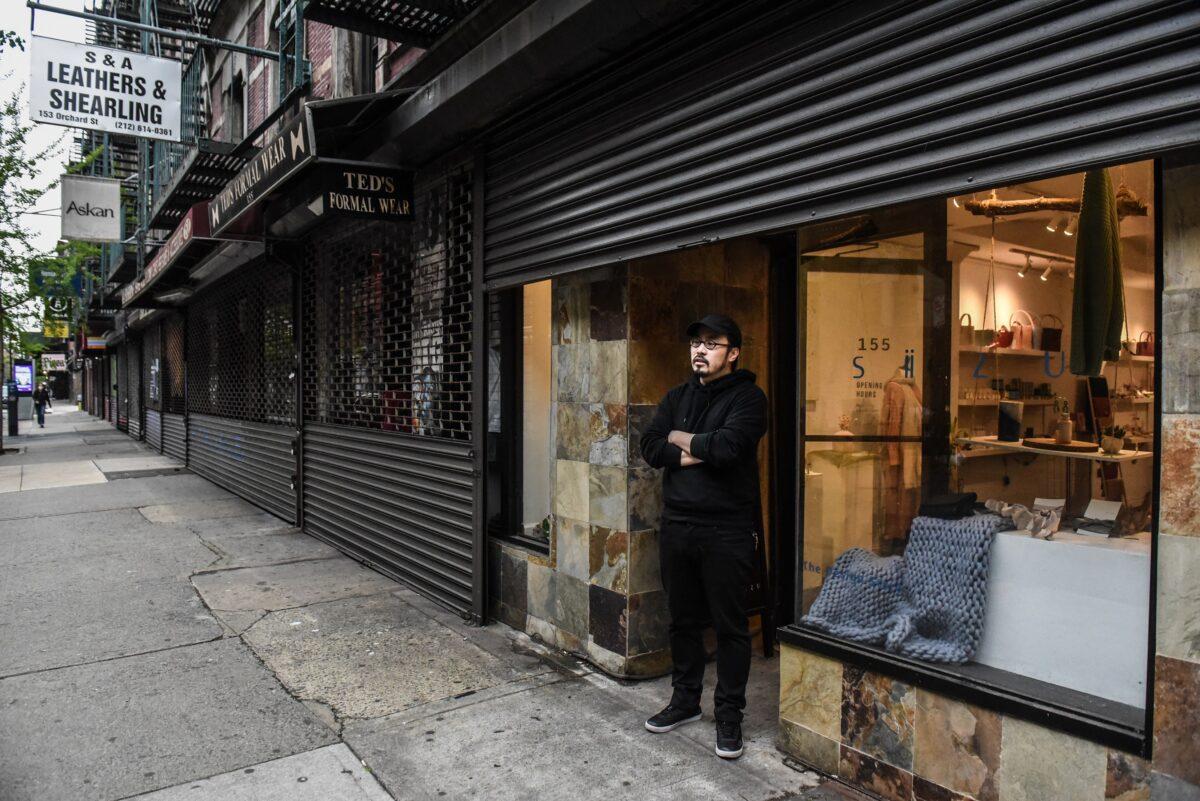 A business proprietor stands in front of his store in the Lower East Side neighborhood in New York City on April 30, 2020. (Stephanie Keith/Getty Images)