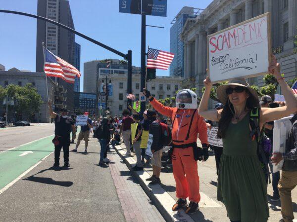 San Francisco protesters hold signs near City Hall on May 1, 2020, to push for reopening California. (Ilene Eng/The Epoch Times)