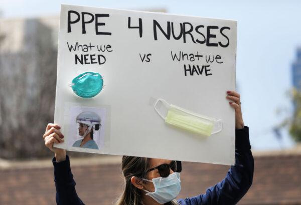 A nurse holds up a sign to protest the lack of personal protective gear available at UCI Medical Center in Orange, Calif., on April 3, 2020. (Mario Tama/Getty Images)