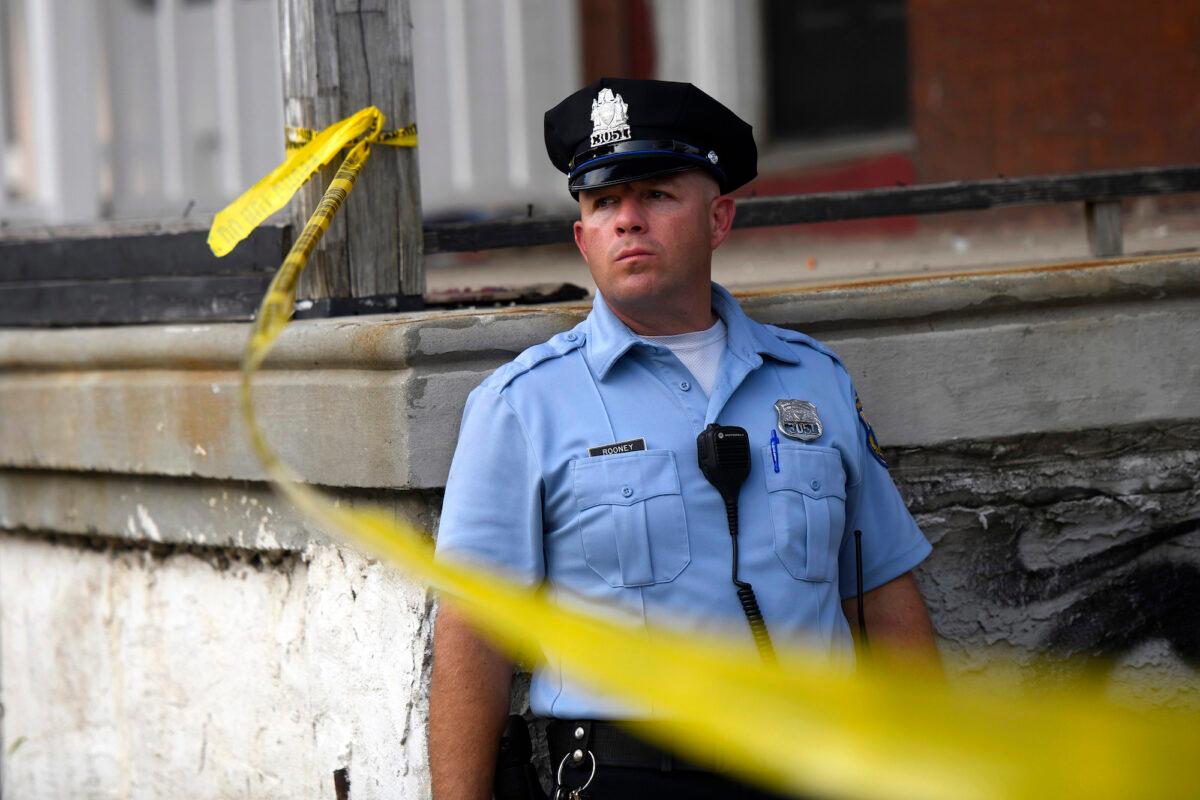 File photo showing a police officer monitoring activity near a residence while responding to a shooting in Philadelphia, Penn., on Aug. 14, 2019. (Mark Makela/Getty Images)