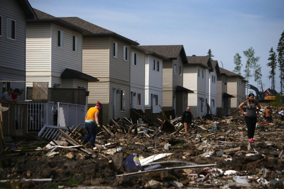 Residents survey the devastated neighborhood of Timberlea in Fort McMurray, Alberta, on June 2, 2016. The pace of Fort McMurray residents' return to the wildfire-ravaged Canadian oil city accelerated, but continued to fall short of expectations. (Cole Burston/AFP via Getty Images)