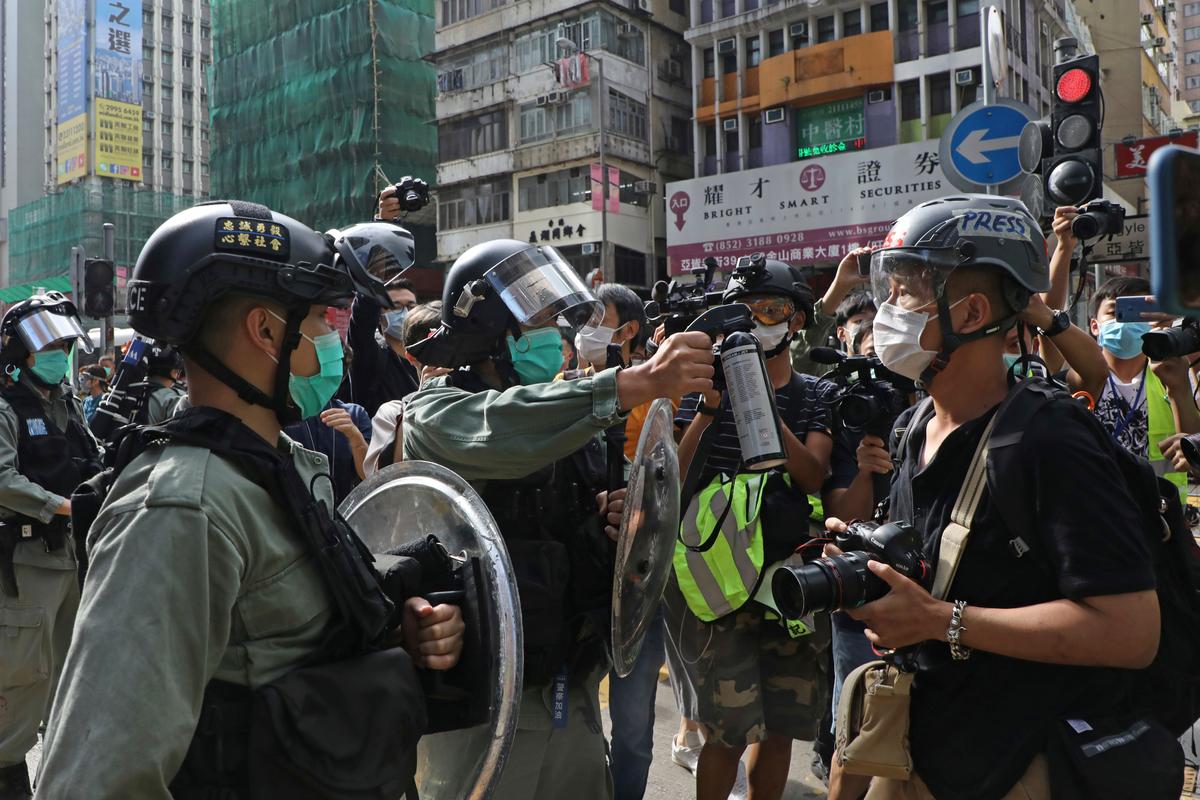 A riot police points the pepper spray to journalists as protesters gather outside a shopping mall in Hong Kong, on May 1, 2020. (Kin Cheung/AP Photo)