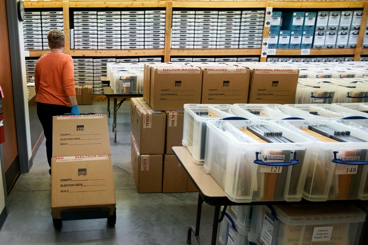 Nadette Cheney wheels in boxes of printed ballots into the storage room of the Lancaster County Election Committee offices in Lincoln, Neb., on April 14, 2020. (Nati Harnik/AP photo)