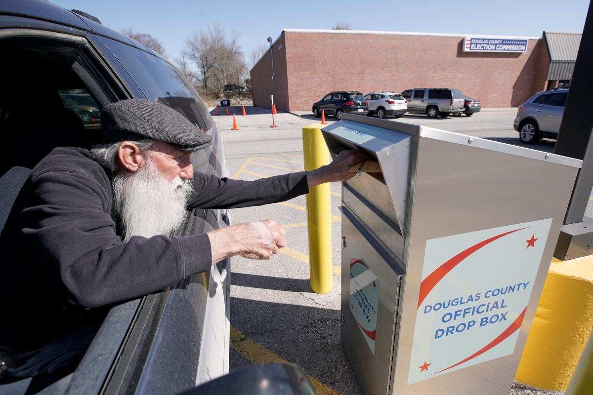 Robert E. Lee inserts his ballot into a drop box outside the Douglas County Election Commission office in Omaha, Neb., on April 10, 2020. (Nati Harnik/AP photo)