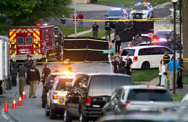 Police investigate at the scene where police in Kansas say a shootout has left both a police officer and a hit-and-run suspect dead, in Overland Park, Kan., on May 3, 2020. (Tammy Ljungblad/The Kansas City Star via AP)